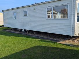 A mobile home with windows and grass at Beachcomber Cabin Dog Friendly Anderby Creek Lincolnshire