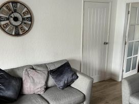 A living room with a clock and sofa at The Old Barn in Manchester