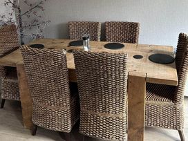 A dining table with woven chairs and placemats at the property in location