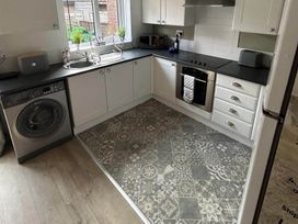 A kitchen with a washing machine and oven at The Old Barn in Manchester