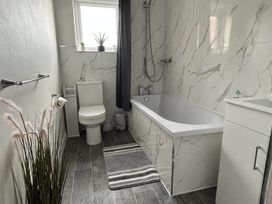A bathroom with a bath tub, toilet, and sink at The Old Barn in Manchester