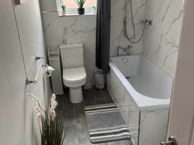 A bathroom with a tub, toilet, and sink at The Old Barn in Manchester