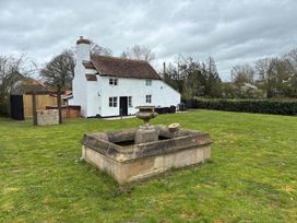 A garden with a fountain in front of a house at The Old Barn in Manchester
