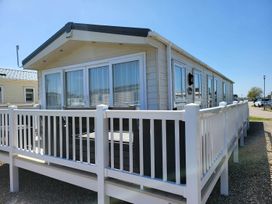 A mobile home with a deck and railing at a holiday park