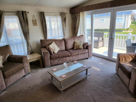 A living room with a sofa, armchairs, and a coffee table at the property in unspecified location