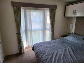 A bedroom with a bed and curtains at the property location