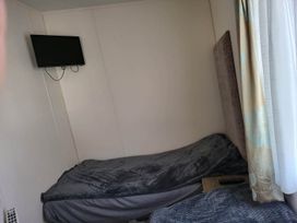 A bedroom with a bed and television mounted on the wall
