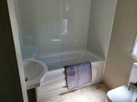 A bathroom with a bathtub, sink, and toilet at The Old Barn in Manchester
