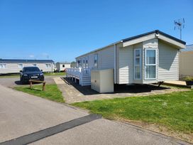 A mobile home with a car parked outside at a caravan park