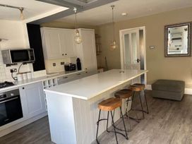 A kitchen with a counter and bar stools at The Old Barn in Manchester