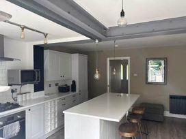 A kitchen with a countertop and bar stools at The Old Barn in Manchester
