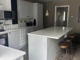 A kitchen with a countertop and bar stools at the property location