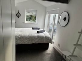 A bedroom with a bed and a mirror at The Old Barn in Manchester