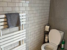 A bathroom with a toilet and towel rack at the property location
