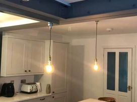 A kitchen with light fixtures and cabinets at The Old Barn in Manchester
