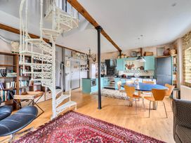 A kitchen with a spiral staircase and seating area at Beautiful Pad Near World Heritage Jurassic Coast in Pymore near Bridport