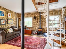 A living room with a spiral staircase and a fireplace at Beautiful Pad Near World Heritage Jurassic Coast in Pymore near Bridport
