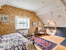 A bedroom with a bed and a hanging chair at Beautiful Pad Near World Heritage Jurassic Coast in Pymore near Bridport