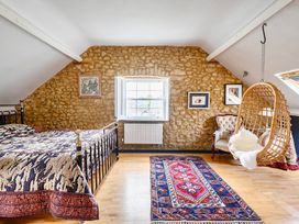 A bedroom with a bed and a hanging chair at Beautiful Pad Near World Heritage Jurassic Coast in Pymore near Bridport