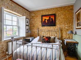A bedroom with a bed and art on the wall at Beautiful Pad Near World Heritage Jurassic Coast, Pymore near Bridport