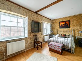 A bedroom with a bed, chair, window, and radiator at Beautiful Pad Near World Heritage Jurassic Coast, Pymore near Bridport