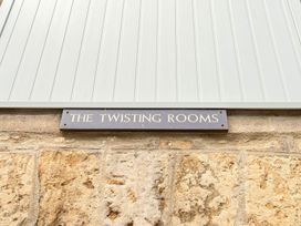 A sign reading THE TWISTING ROOMS on a stone wall
