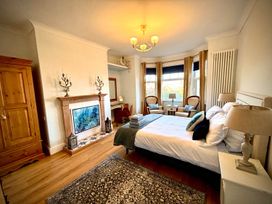 A bedroom with a bed and armchairs at 5 Guests  2 Bedrooms  Free Parking 1min Beach Llandudno