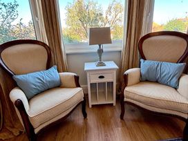 Two armchairs and a lamp next to a window at 5 Guests  2 Bedrooms  Free Parking 1min Beach Llandudno