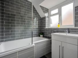 A bathroom with a bathtub, sink, and window at Detached House in Quiet Village Pets Allowed in Ashbocking near Otley, Suffolk