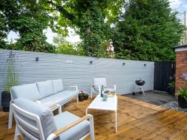 A garden area with a sofa, table, and grill at Detached House in Quiet Village Pets Allowed Ashbocking near Otley, Suffolk