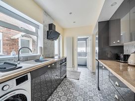 A kitchen with a sink and washing machine at Cottage Sleeps 6 with Parking and Garden in Bridlington