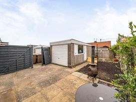 An outdoor area with a shed, fence, and fire pit at Cottage Sleeps 6 with Parking and Garden in Bridlington