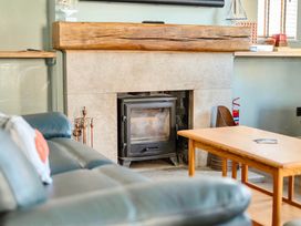 A living room with a fireplace and a wooden table at 4 Bed Sleeps 8 Pool Table Sea View Parking in Swanage