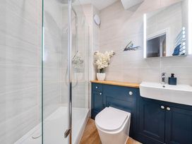 A bathroom with shower, toilet, sink and vanity unit at 4 Bed Sleeps 8 Pool Table Sea View Parking in Swanage