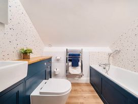 A bathroom with a sink, toilet, towel rack, and bath at 4 Bed Sleeps 8 Pool Table Sea View Parking in Swanage