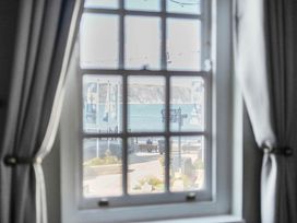 A window with a view of the ocean and pathway at 4 Bed Sleeps 8 Pool Table Sea View Parking in Swanage