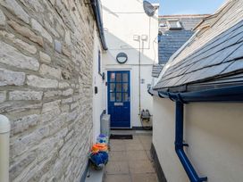 An outdoor pathway with a blue door and a stone wall at 4 Bed Sleeps 8 Pool Table Sea View Parking, Swanage