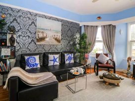 A living room with a couch, table, and bookshelf at the property