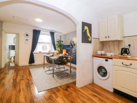 A kitchen with dining table and washer at The Old Barn in Manchester