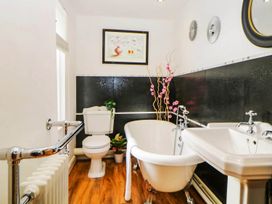A bathroom with a bathtub, toilet, and sink at The Old Barn in Manchester