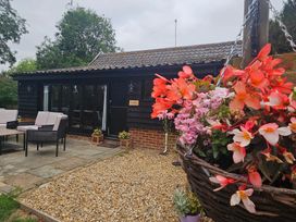 An outdoor seating area with a table and flowers at Lily's Cottage Suffolk Sleeps 2 with Pets Mendlesham Green near Stowmarket
