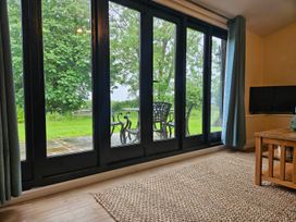 A living room with glass doors leading to outdoor furniture at Lily's Cottage Suffolk Sleeps 2 with Pets Mendlesham Green near Stowmarket