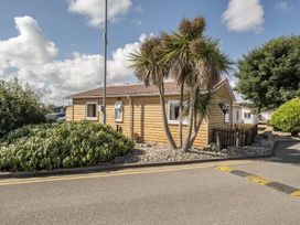 A log cabin with palm trees and a hedge at Seaside Chalet Retreat in Bridlington