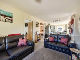A living room with sofas and a kitchen view at Seaside Chalet Retreat in Bridlington