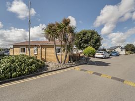 A building with palm trees and cars at Seaside Chalet Retreat in Bridlington