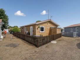 A cabin with a fenced area and outdoor seating at Seaside Chalet Retreat in Bridlington