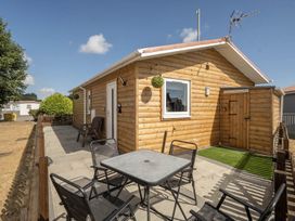 A log cabin with a table and chairs outside at Seaside Chalet Retreat in Bridlington