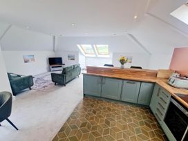 An open plan living room with a sofa and kitchen units at Apartment Sleeps 4 with Balcony and Parking in Kingsbridge