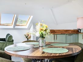 A dining room with a round table and a vase of flowers at Apartment Sleeps 4 with Balcony and Parking in Kingsbridge