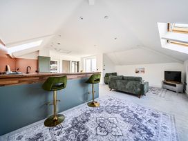 A living room with a sofa and bar stools at Apartment Sleeps 4 with Balcony and Parking in Kingsbridge